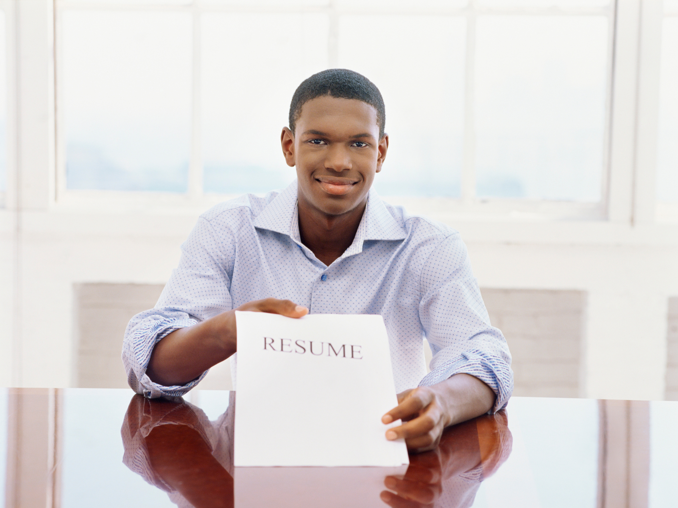 portrait of a young man showing his resume